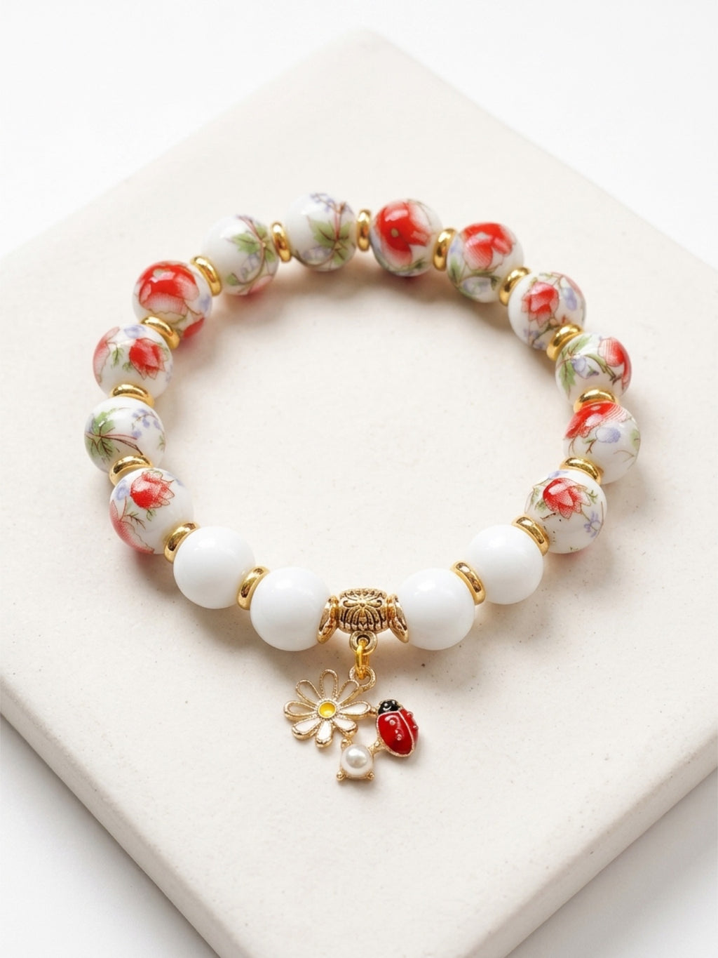 Mia Bracelet – Red Flower Pattern White Porcelain And Chalcedony Beaded Bracelet with Ladybug Charm Handcrafted by Artist Kristine Keina