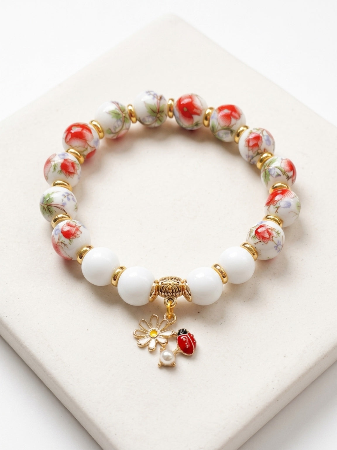 Mia Bracelet – Red Flower Pattern White Porcelain And Chalcedony Beaded Bracelet with Ladybug Charm Handcrafted by Artist Kristine Keina